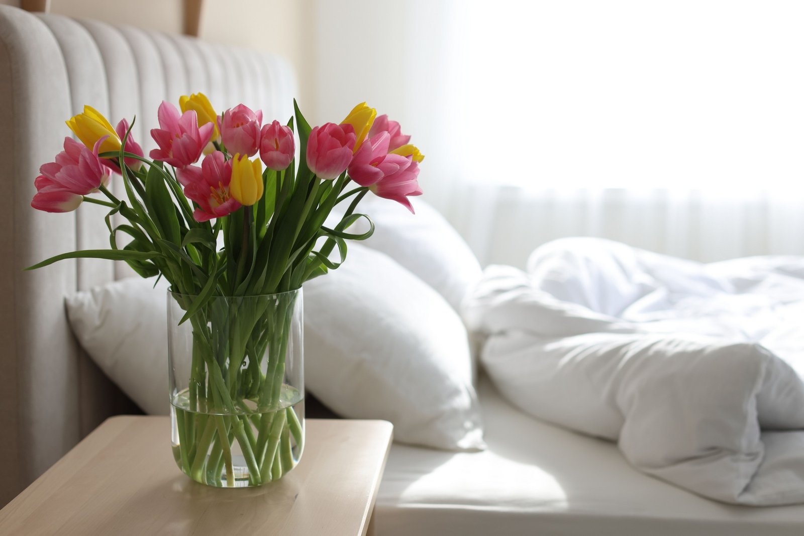 Frisches, aufgeräumtes Schlafzimmer mit offenem Fenster